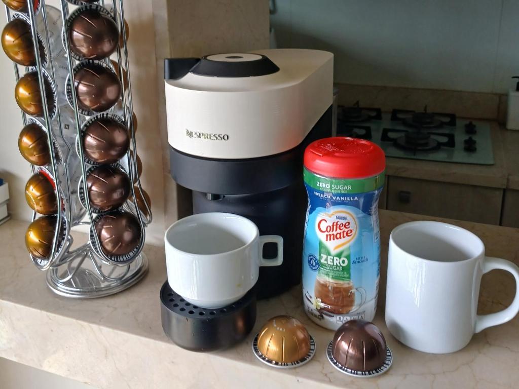 a kitchen counter with cups and a coffee maker and muffins at Apart-Hotel Vista Frontal em Ipanema in Rio de Janeiro