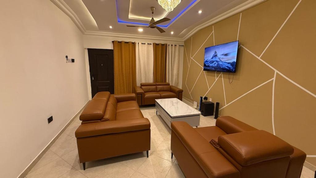 a living room with couches and a flat screen tv at 3 Bedroom House In Oyarifa - Accra in Trofwi