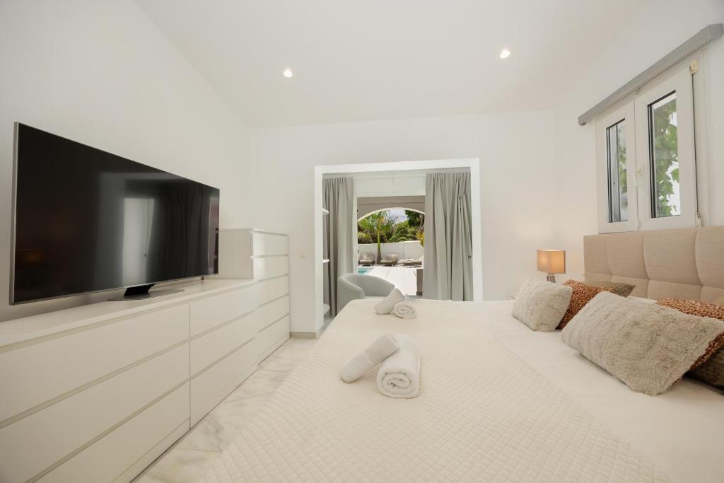 Telewizja i/lub zestaw kina domowego w obiekcie 6 bedroom villa, with heated pool and sea views, next to the beach of Costabella