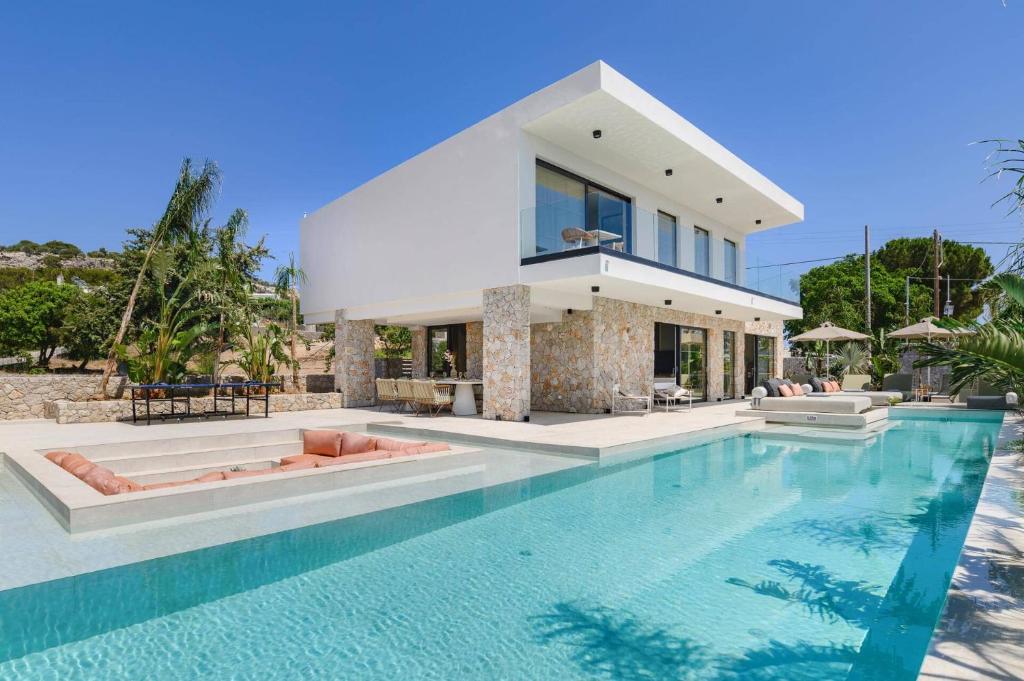 a house with a swimming pool in front of a house at Villa Pefkos Sunset by Villa Plus in Pefki Rhodes