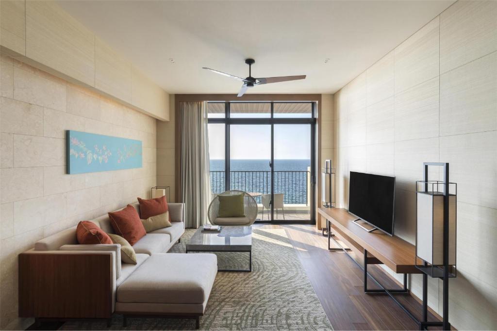 a living room with a couch and a television at Hyatt Regency Seragaki Island Okinawa in Onna