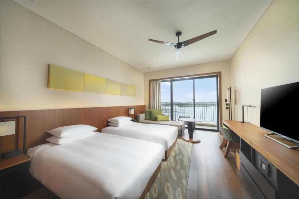 a hotel room with two beds and a flat screen tv at Hyatt Regency Seragaki Island Okinawa in Onna