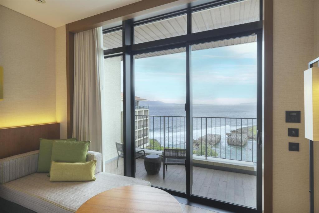 a room with a large window with a view of the ocean at Hyatt Regency Seragaki Island Okinawa in Onna