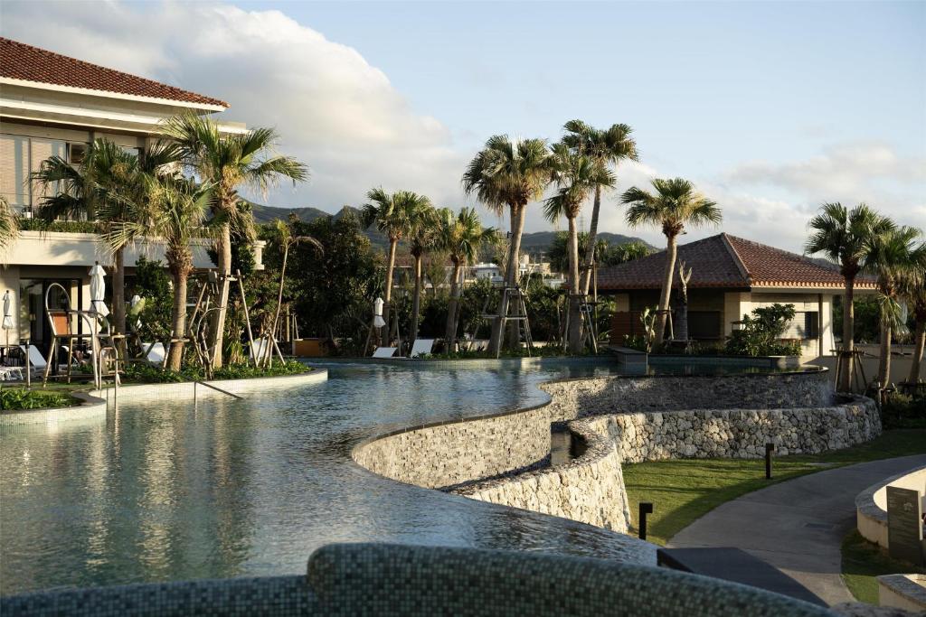 a pool at a resort with palm trees at Hyatt Regency Seragaki Island Okinawa in Onna