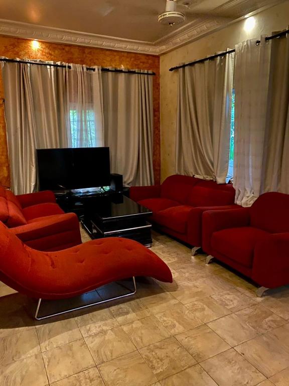 a living room with red couches and a piano at La case du Nord in Bamako
