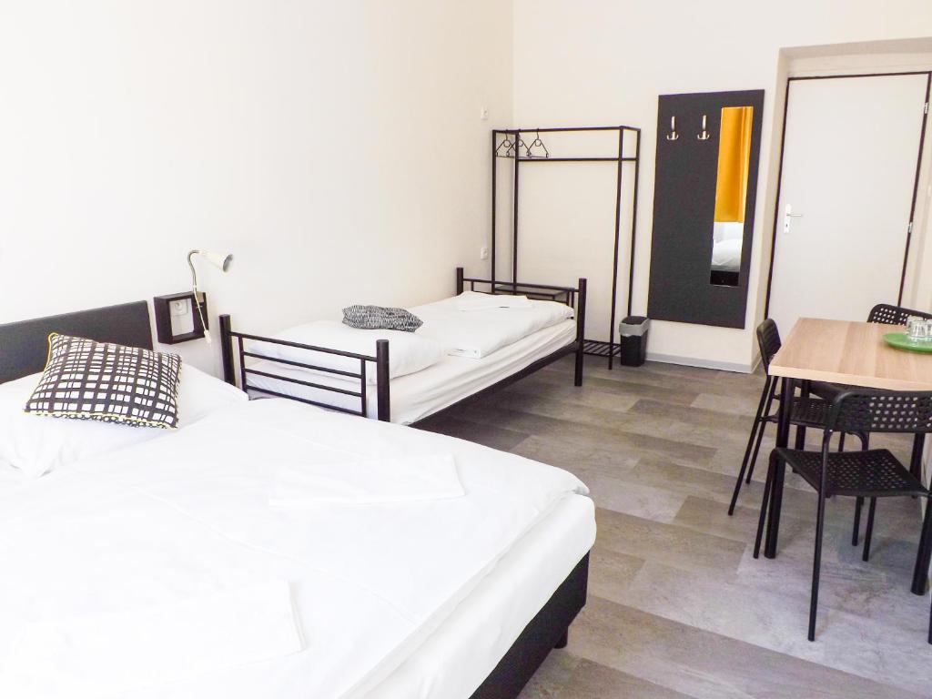 a room with two beds and a table and a table and chairs at Cozy relax Praha Letná D3 in Prague