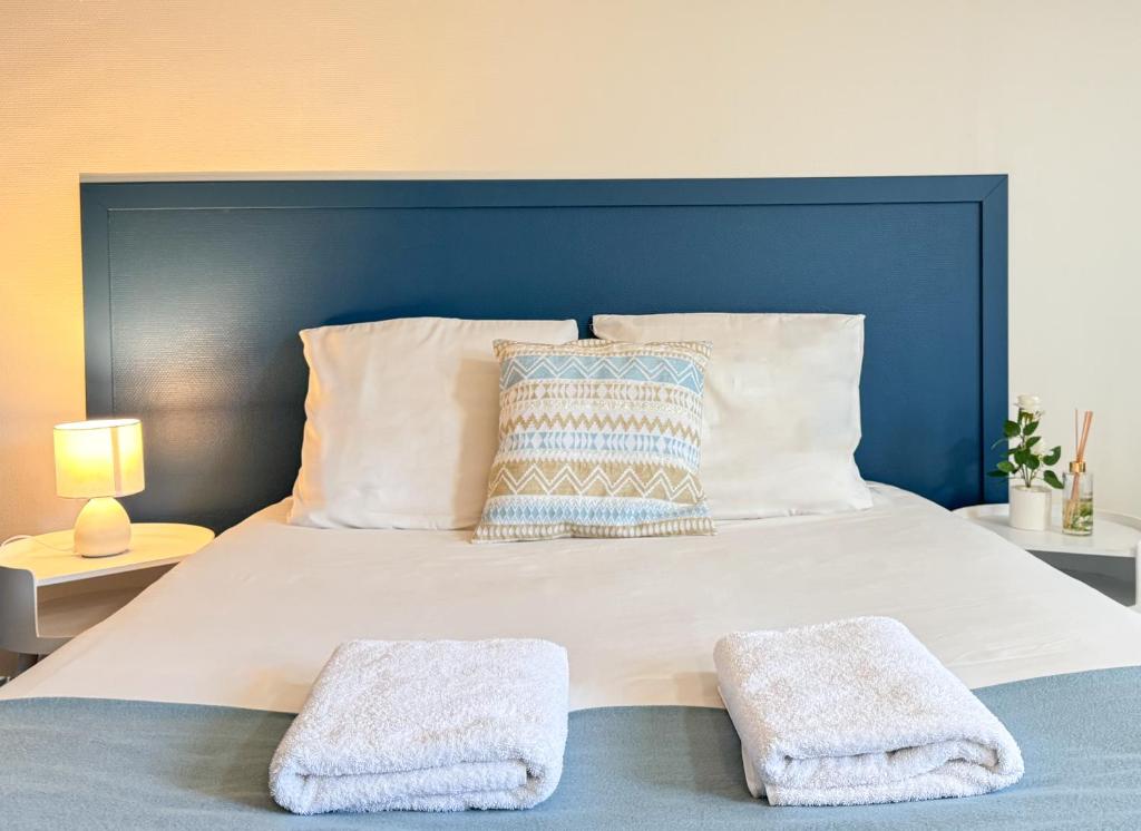 une chambre avec un grand lit avec deux serviettes dessus dans l'établissement Studio Platanes 9 - Proche Disneyland - Parking gratuit - Meaux, à Meaux