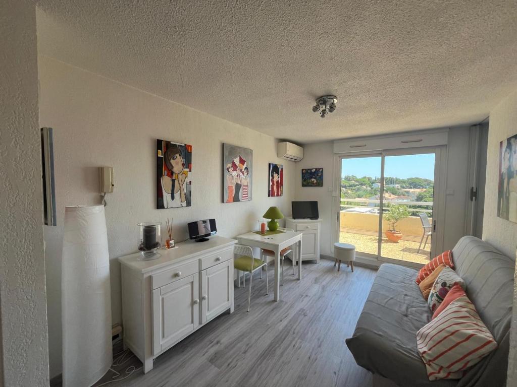 a living room with a couch and a desk at Appartement centre-ville climatisé in Cavalaire-sur-Mer
