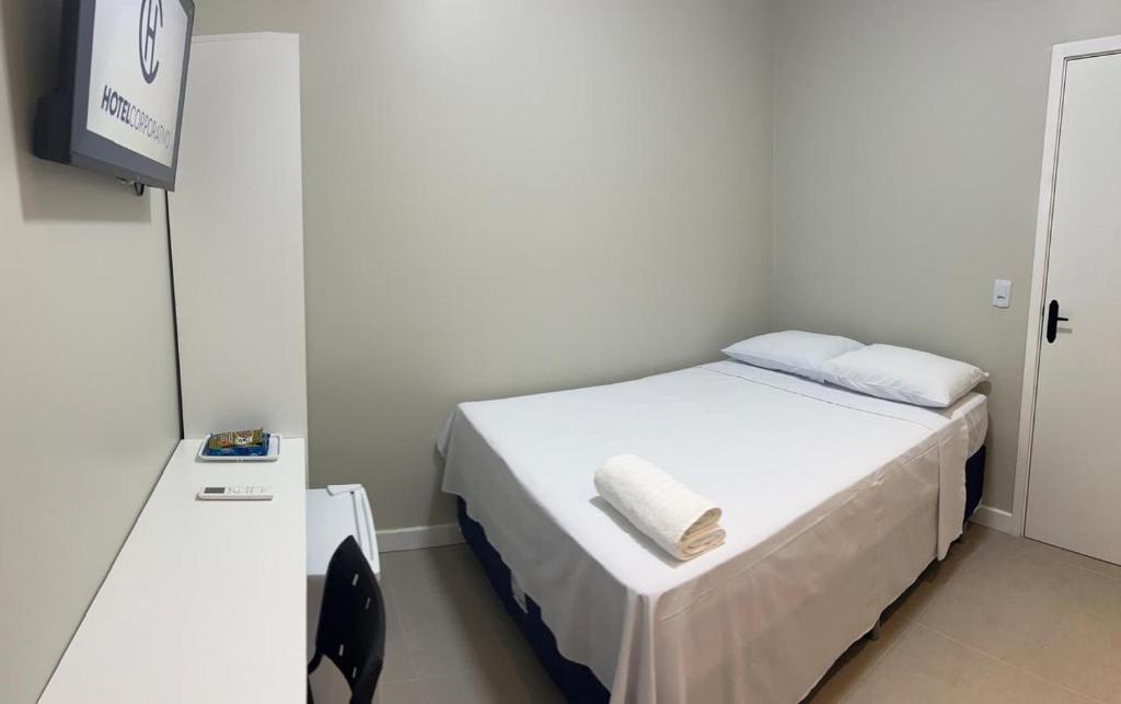 une petite chambre avec un lit avec deux oreillers dessus dans l'établissement Hotel Corporativo Paragominas, à Paragominas