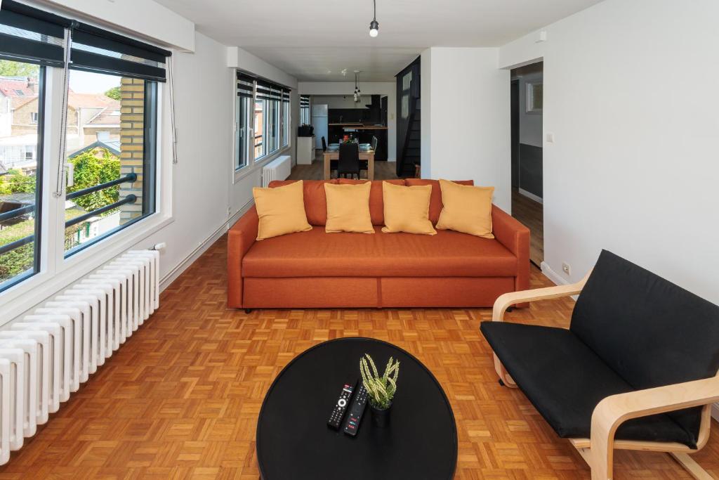 a living room with a couch and two chairs at Une escale à Malo in Dunkerque