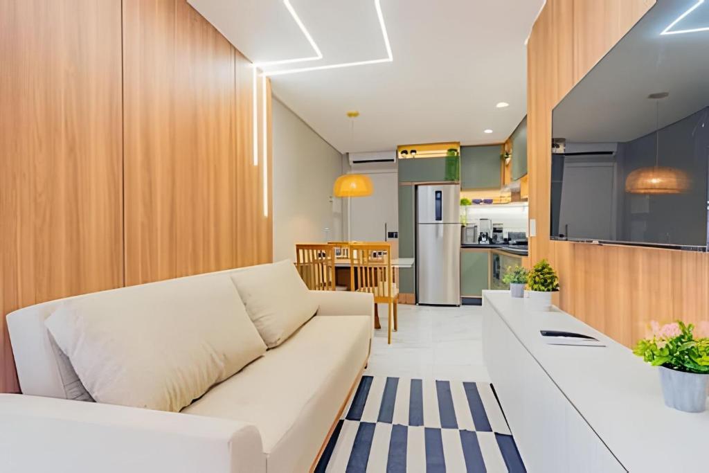 Una sala de estar con un sofá blanco y una cocina. en Atlantis 312: Luxury and Style Porto de Galinhas, en Porto de Galinhas