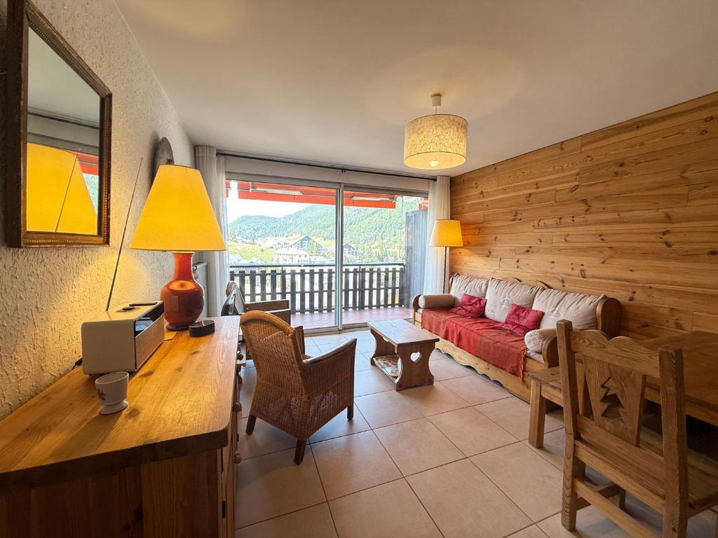 - un salon avec un canapé rouge et une fenêtre dans l'établissement Appartement calme avec balcon et vue montagne pour 4 pers - FR-1-515-227, à Villard-de-Lans