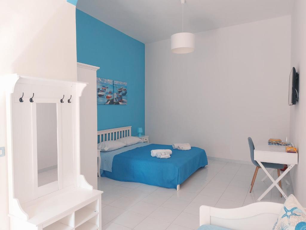a bedroom with a bed and a table and a desk at affittacamere lu mari lu suli lu ventu in Gela