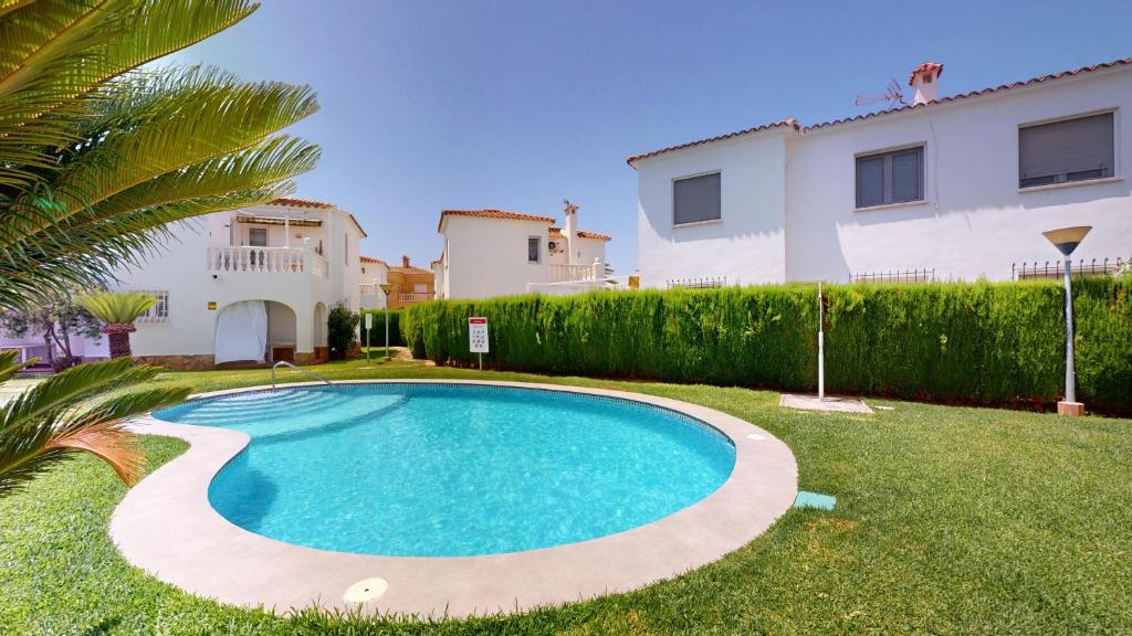 a swimming pool in the yard of a house at Peony by ON Travel in Oliva