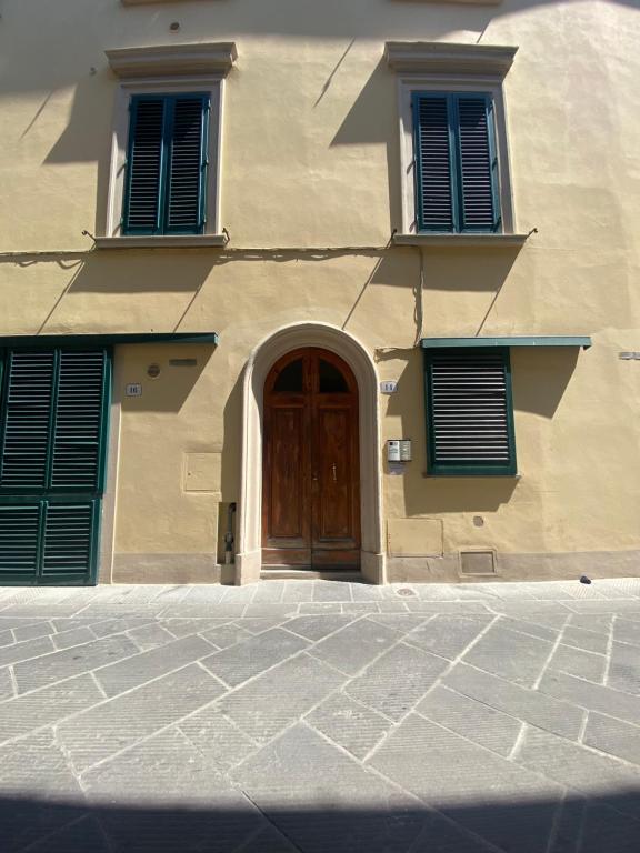 a building with a wooden door and two windows at Il Giardino di Barbara in Prato