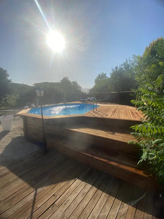un jacuzzi assis sur une terrasse en bois avec le soleil dans l'établissement Au plaisir du lac, à Sainte-Marie-du-Lac-Nuisement 