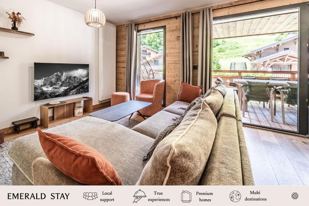 un salon avec un canapé et une télévision dans l'établissement Apartment Edelweiss Les Gets - BY EMERALD STAY, aux Gets