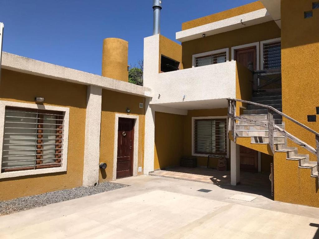 una casa gialla con una scala di fronte di La Rioja 4880 n1 a La Lucila del Mar