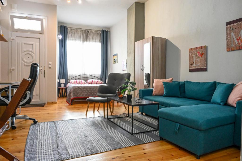 a living room with a blue couch and a table at Penelope's and John's House in Kavála