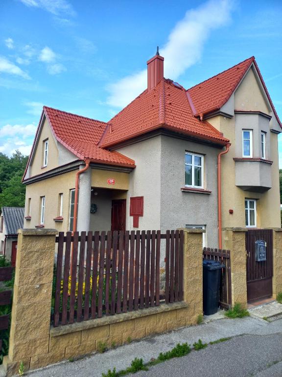 a house with a fence and a red roof at Villa Oliva in Český Krumlov