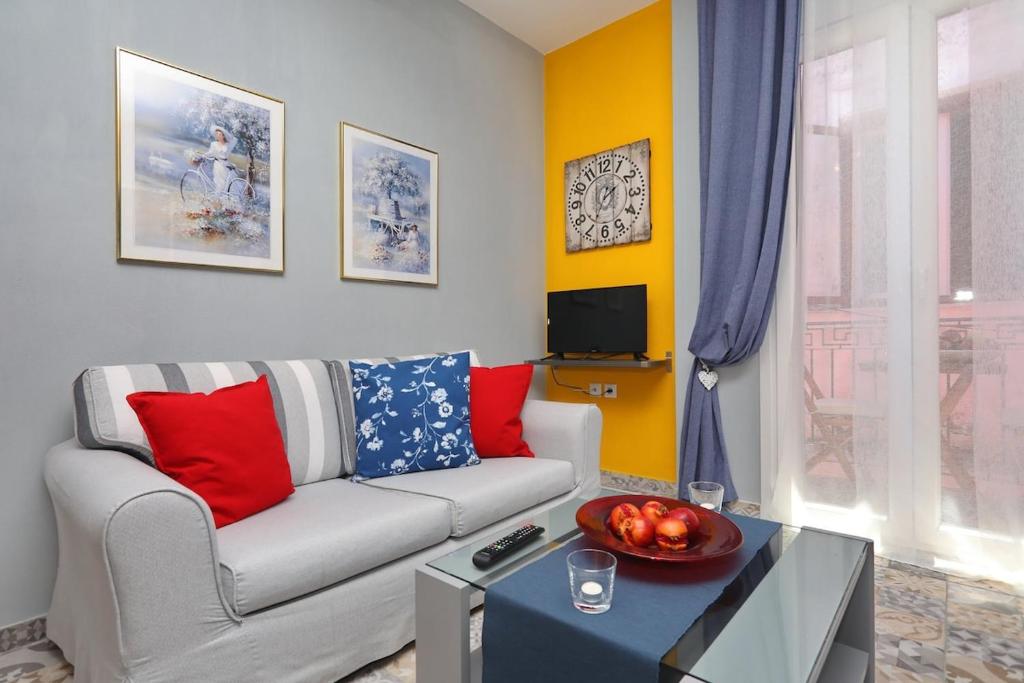 a living room with a couch and a table at Fouxia-Yellow in Skopelos Town