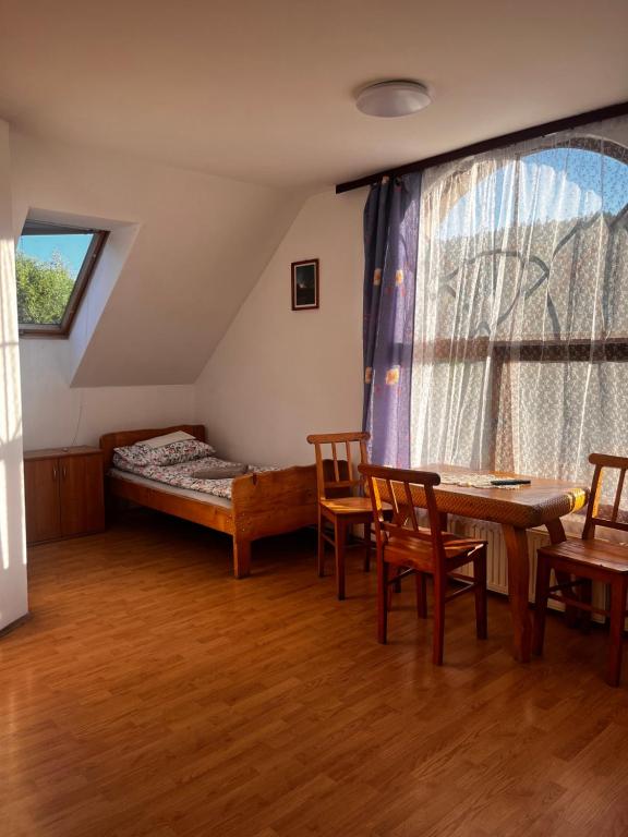 a bedroom with a bed and a table and chairs at MAGURA in Pszczeliny