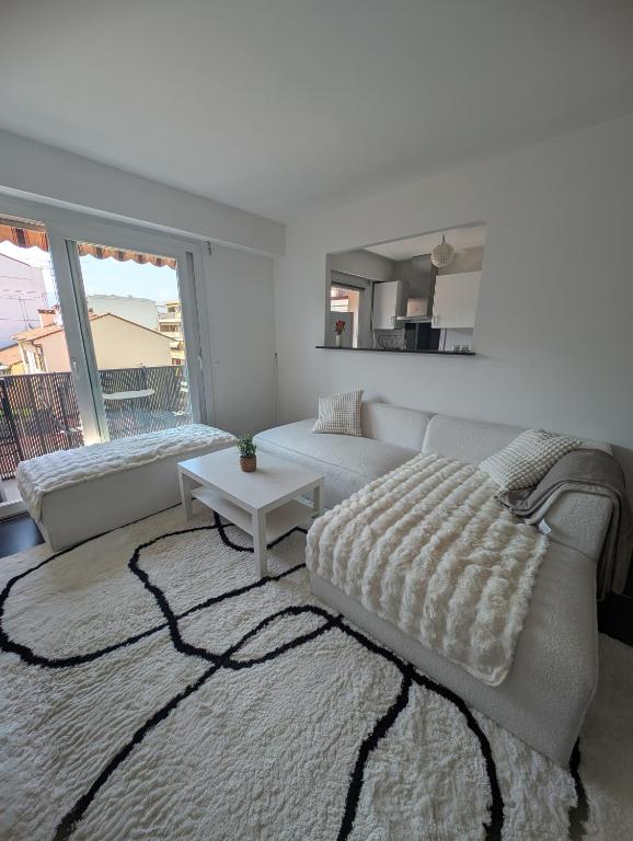 un salon blanc avec un canapé et une table dans l'établissement La parenthèse azuréenne, à Cagnes-sur-Mer