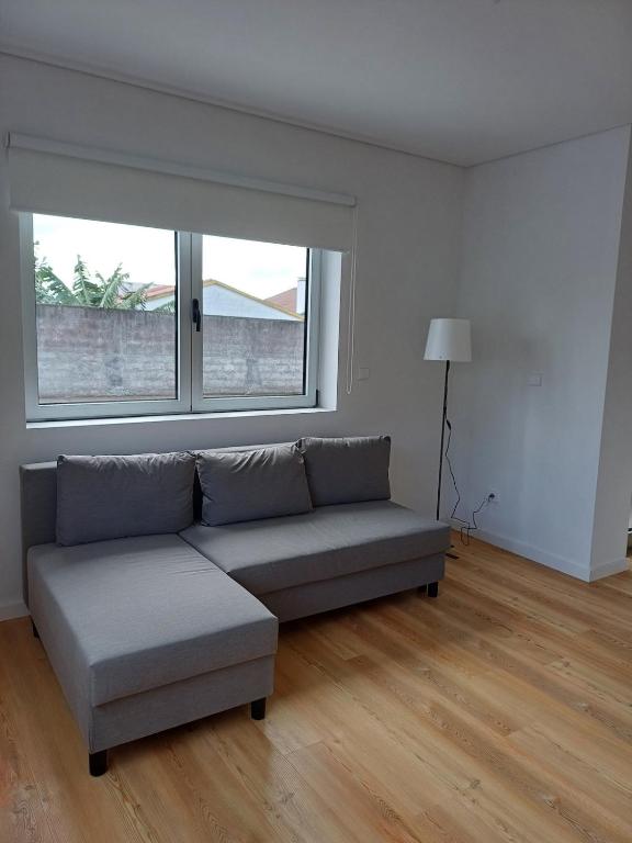 a living room with a couch and a window at Azure Escape Azores in Arrifes