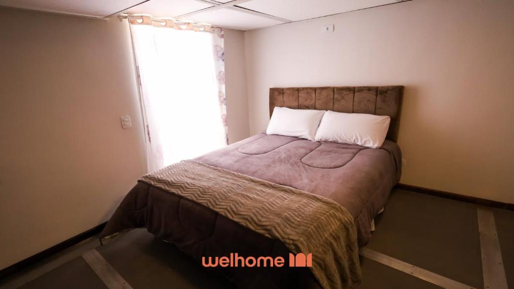 a small bedroom with a bed with a window at Loft no Centro de Ponta Grossa com Mezanino in Ponta Grossa