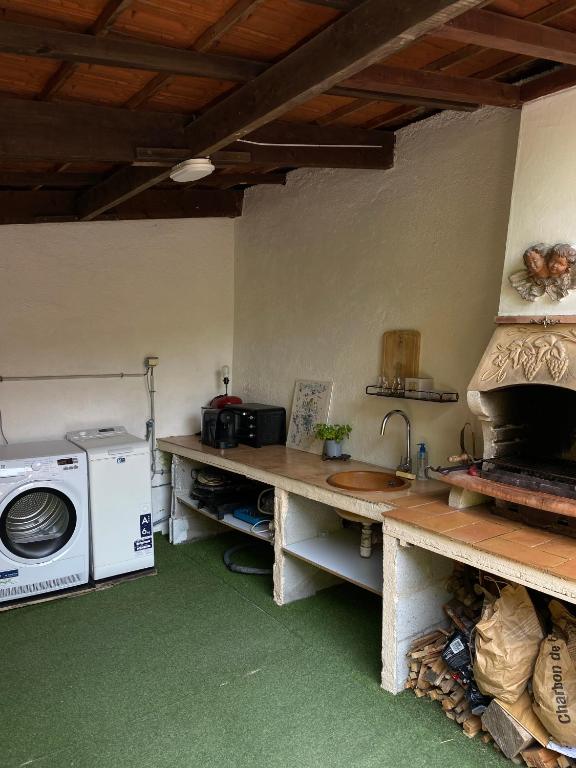 eine Küche mit einem Herd und einer Waschmaschine in der Unterkunft Villa Serenice - F2 au calme, climatisé, WIFI et parking gratuit in Nizza