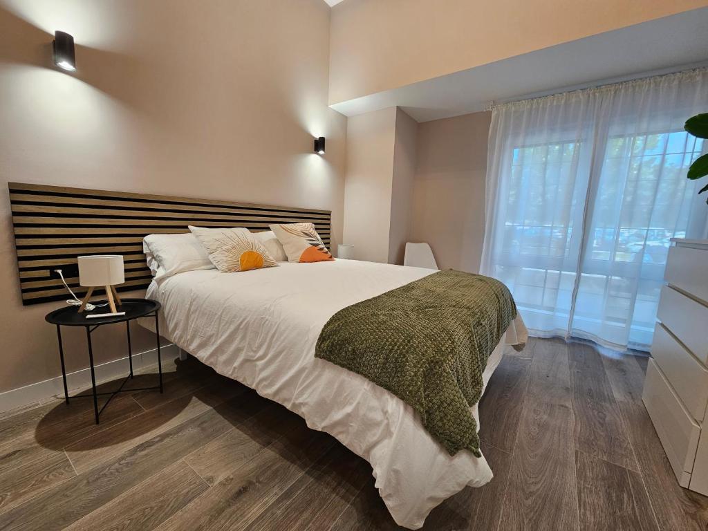 Un dormitorio con una cama grande y una ventana. en Loft coqueto en corralillos UAT01901, en Pamplona