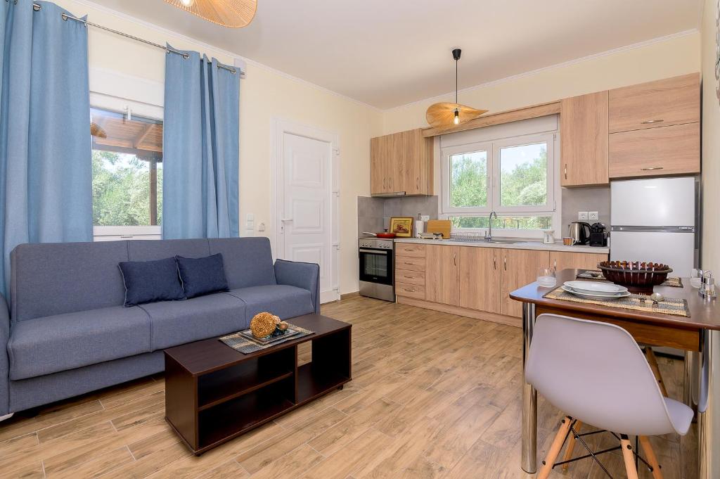 a living room with a blue couch and a kitchen at Olive House 3 in Alexandroupoli
