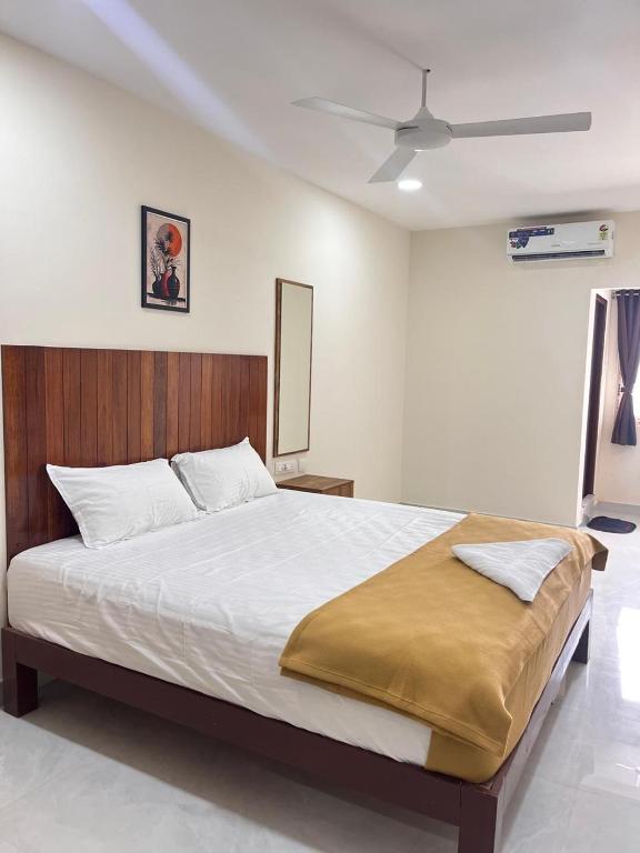 a bedroom with a large white bed with a ceiling at Ram Residency chengalpattu in Ottivākkam