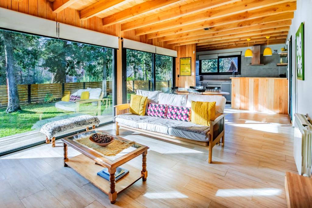 una sala de estar con un sofá y una mesa en BOG Cherry House, en Villa La Angostura