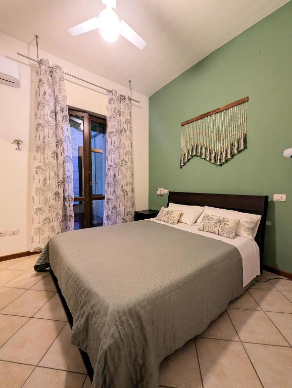 sypialnia z łóżkiem i zieloną ścianą w obiekcie As Easy w Asyżu