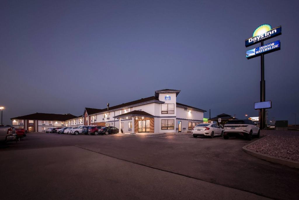 un edificio con un cartel en un estacionamiento en Days Inn by Wyndham Mitchell SD, en Mitchell