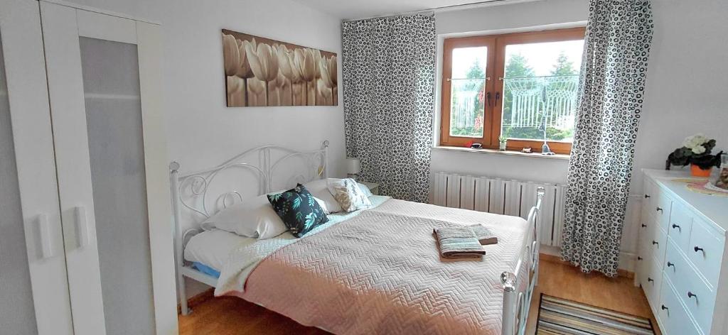 a white bedroom with a bed and a window at Willa Szymusiowa Szczyrk Pokoje i Apartamenty Przy Gondoli in Szczyrk