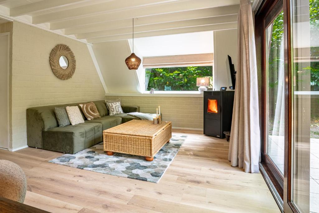 een woonkamer met een bank en een tafel bij Boshuisje Rekem - Kitoko in Lanaken