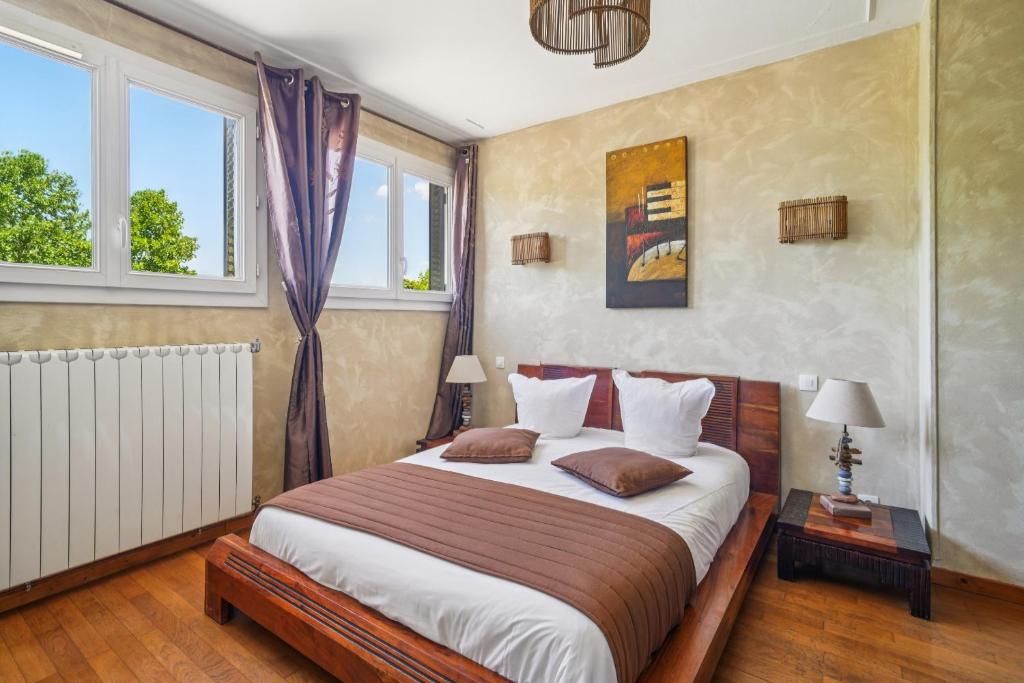 a bedroom with a bed and two windows at Roissy Chambres in Roissy-en-France