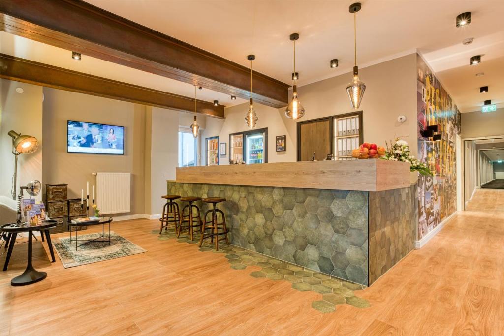 a bar in the middle of a room with wooden floors at AVA Boutique Hotel in Ingolstadt