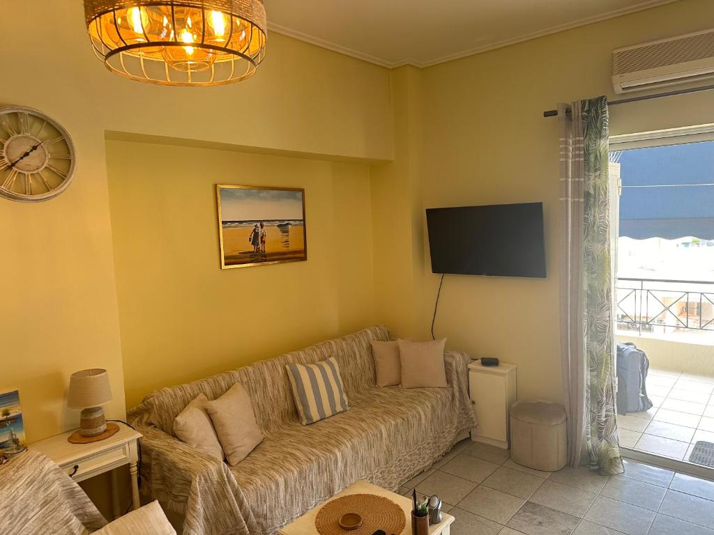 ein Wohnzimmer mit Couch und Flachbildfernseher in der Unterkunft Sunnyhomes Ipsilantou in Loutraki