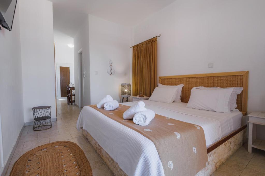 ein Schlafzimmer mit einem großen Bett, auf dem Handtücher liegen in der Unterkunft Studios Eliza in Livadion