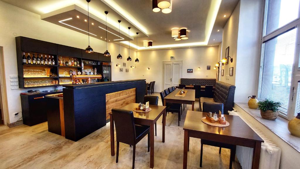 restauracja ze stołami i krzesłami oraz bar w obiekcie Hotel Grand w mieście Řevnice