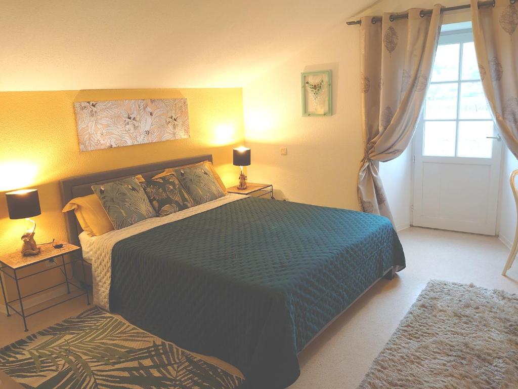 a bedroom with a bed and two lamps and a window at La Buissière - Gite Savane in Duravel