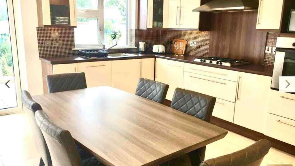 une cuisine avec une table et des chaises en bois dans l'établissement Shangri-La Spacious Family Townhouse large free carpark, à Killarney