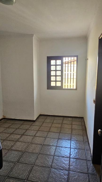 an empty room with a window and a tiled floor at Casa com suítes quartos praias e centro histórico in São Luís