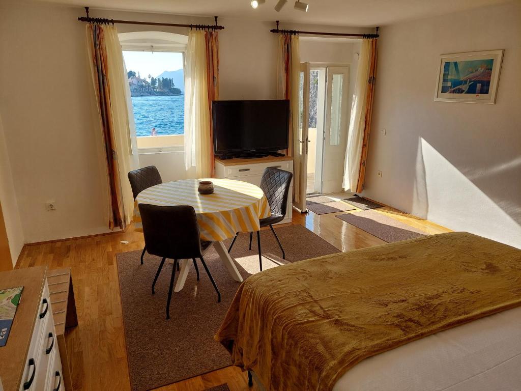 a bedroom with a bed and a table and a television at Apartment Nona in Korčula