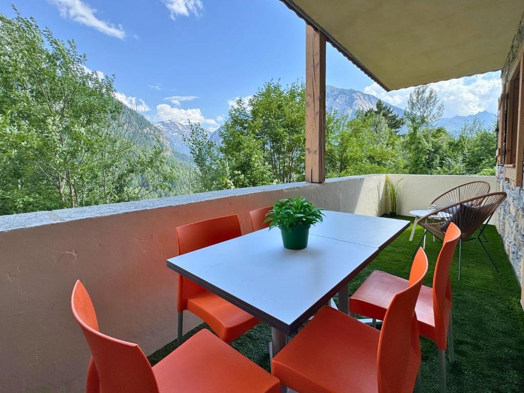 d'une table et de chaises sur un balcon avec vue sur les montagnes. dans l'établissement Borselier vue Montagne, Spa & Terrasse, à Champagny-en-Vanoise