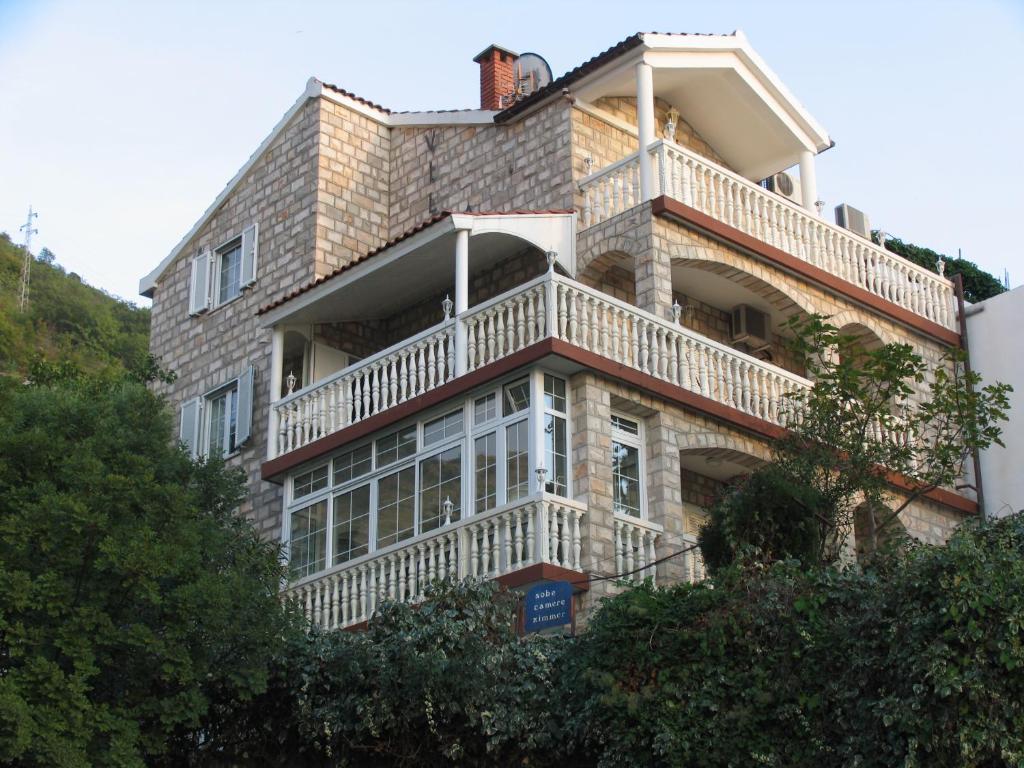 a large brick building with a balcony on it at Apartments Sana in Sveti Stefan