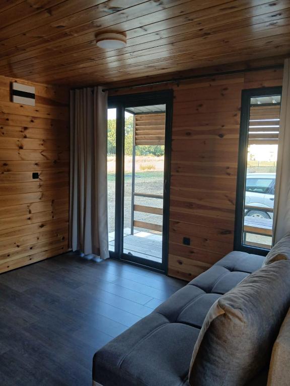 a living room with a couch and wooden walls at Corner Bungalow in Ulcinj